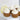 Cupcakes with lemon frosting on a white plate with lemon slices.
